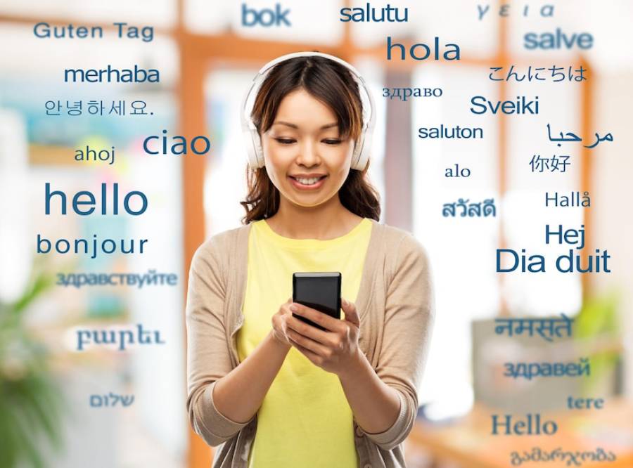 A person in headphones holds a smartphone, surrounded by greetings in various languages, set against a bright, modern background. 